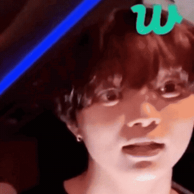 A Close Up Of A Person 'S Face With A Green Letter W On Top Of It . GIF