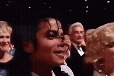 A Close Up Of A Person 'S Face With A Group Of People Behind Them . GIF