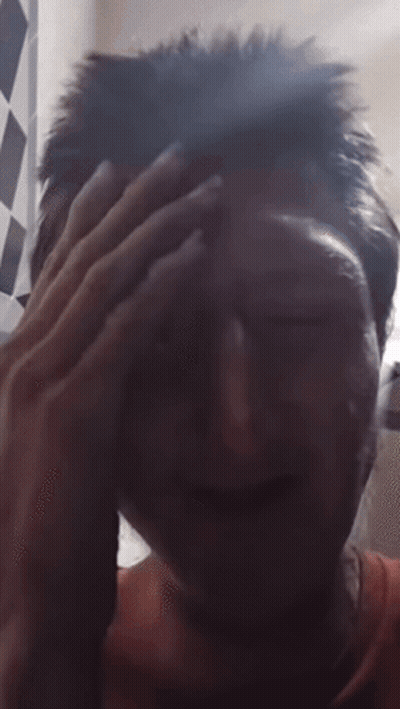 A Close Up Of A Person 'S Face With A Hand On Their Forehead GIF