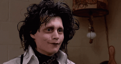 A Close Up Of A Person 'S Face With A Lamp On The Wall In The Background GIF