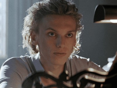 A Close Up Of A Person 'S Face With A Light Behind Them GIF