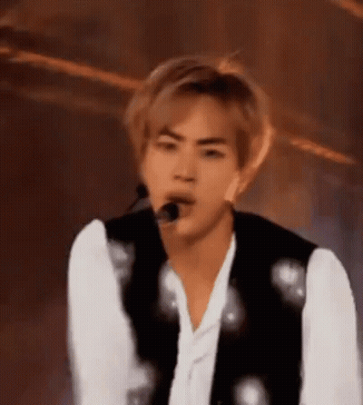 A Close Up Of A Person 'S Face With A Microphone In His Mouth . GIF