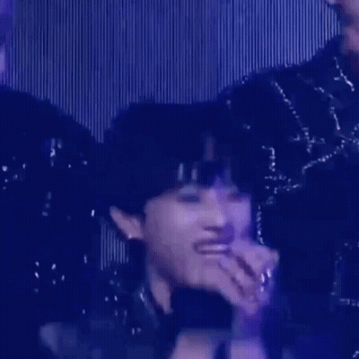 A Close Up Of A Person 'S Face With A Microphone In Their Hand . GIF