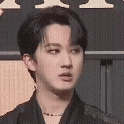 A Close Up Of A Person 'S Face With A Necklace Around Their Neck . GIF