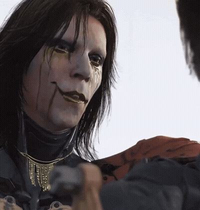 A Close Up Of A Person 'S Face With A Necklace On It GIF