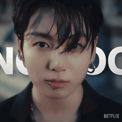 A Close Up Of A Person 'S Face With A Netflix Logo Behind Him GIF