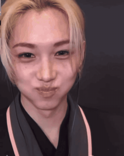 A Close Up Of A Person 'S Face With A Pink Stripe On The Collar GIF