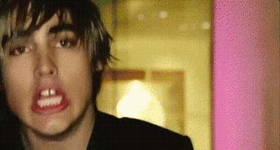 A Close Up Of A Person 'S Face With A Pink Wall In The Background GIF