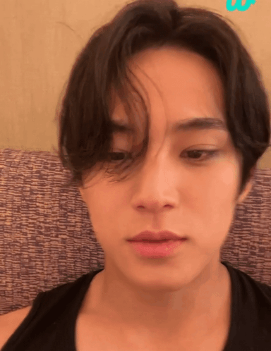 A Close Up Of A Person 'S Face With A Purple Cushion In The Background GIF