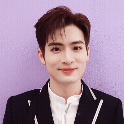 A Close Up Of A Person 'S Face With A Purple Wall In The Background GIF
