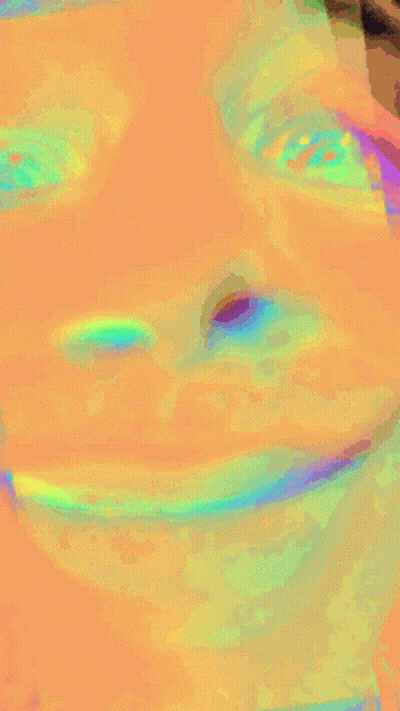 A Close Up Of A Person 'S Face With A Rainbow Of Colors GIF
