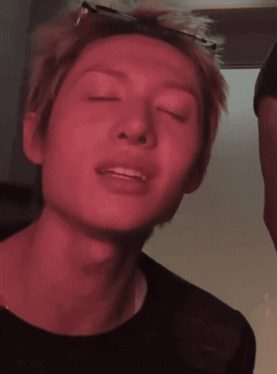A Close Up Of A Person 'S Face With A Red Background GIF