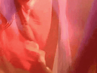 A Close Up Of A Person 'S Face With A Red Background And A Blurred Background . GIF