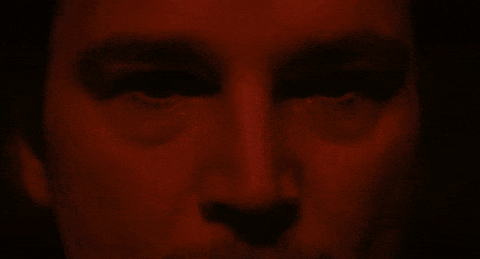 A Close Up Of A Person 'S Face With A Red Background GIF
