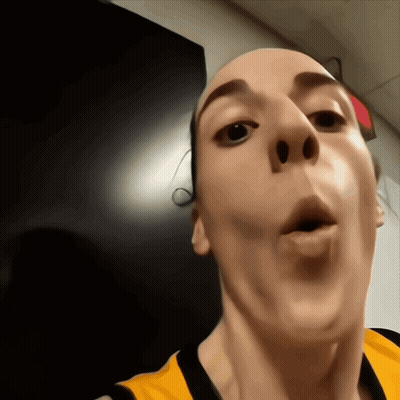 A Close Up Of A Person 'S Face With A Red Exit Sign In The Background GIF
