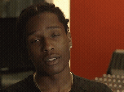 A Close Up Of A Person 'S Face With A Red Wall In The Background GIF