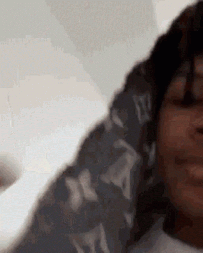 A Close Up Of A Person 'S Face With A Scarf Around Their Neck . GIF