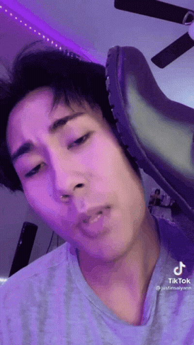 A Close Up Of A Person 'S Face With A Shoe On It . GIF