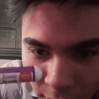 A Close Up Of A Person 'S Face With A Tube Of Scenic Breath GIF