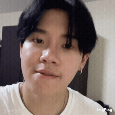 A Close Up Of A Person 'S Face With A White Shirt And Black Hair . GIF