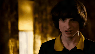 A Close Up Of A Person 'S Face With A Yellow Collar And A Black Shirt . GIF