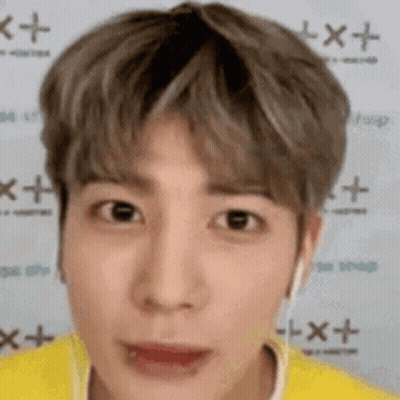 A Close Up Of A Person 'S Face With A Yellow Shirt And Headphones On . GIF