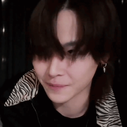 A Close Up Of A Person 'S Face With A Zebra Print Jacket And Earrings . GIF