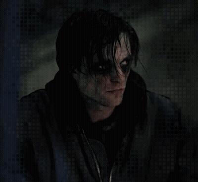 A Close Up Of A Person 'S Face With Black Eyes And A Black Jacket On . GIF