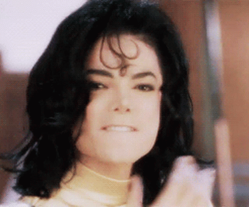 A Close Up Of A Person 'S Face With Black Hair And A Smile GIF