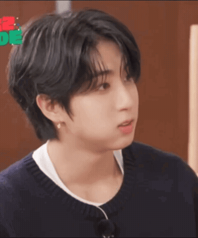 A Close Up Of A Person 'S Face With Black Hair And A White Shirt . GIF