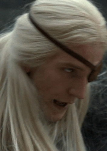 A Close Up Of A Person 'S Face With Blonde Hair And An Eye Patch GIF