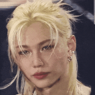 A Close Up Of A Person 'S Face With Blonde Hair And Earrings GIF