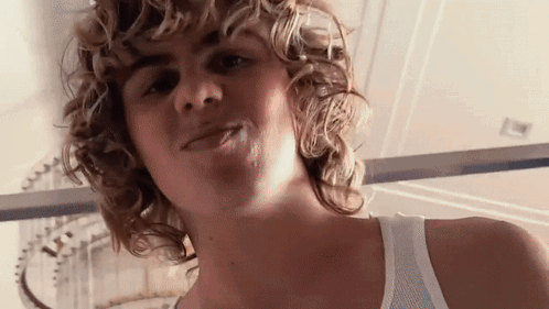 A Close Up Of A Person 'S Face With Curly Hair GIF