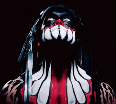 A Close Up Of A Person 'S Face With Dreadlocks And Red And White Paint GIF