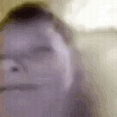 A Close Up Of A Person 'S Face With Glasses And A Blurred Background . GIF