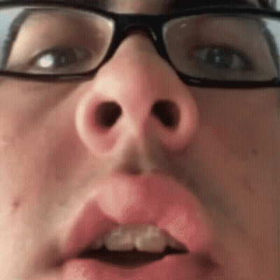 A Close Up Of A Person 'S Face With Glasses And A Pink Lip . GIF