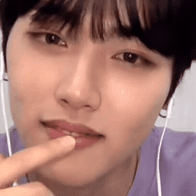 A Close Up Of A Person 'S Face With Headphones On And A Finger In Their Mouth . GIF