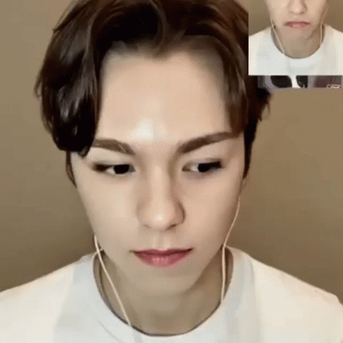 A Close Up Of A Person 'S Face With Headphones On While Talking On A Video Call . GIF