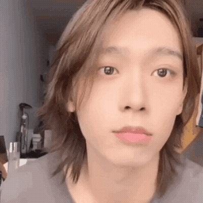 A Close Up Of A Person 'S Face With Long Hair And A Pink Lip . GIF