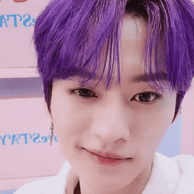 A Close Up Of A Person 'S Face With Purple Hair And A White Shirt . GIF