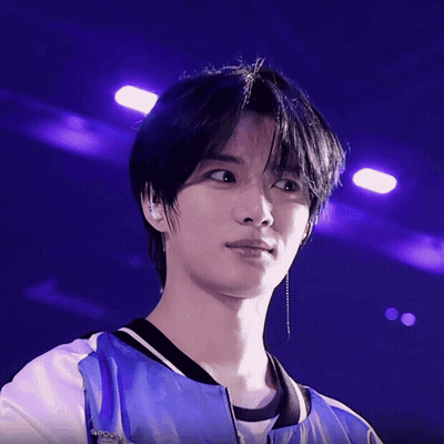 A Close Up Of A Person 'S Face With Purple Lights Behind Him GIF