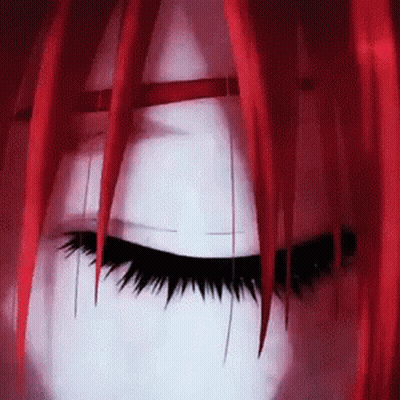 A Close Up Of A Person 'S Face With Red Hair And Long Eyelashes . GIF
