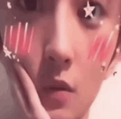 A Close Up Of A Person 'S Face With Stars On It And A Hand On Their Face . GIF