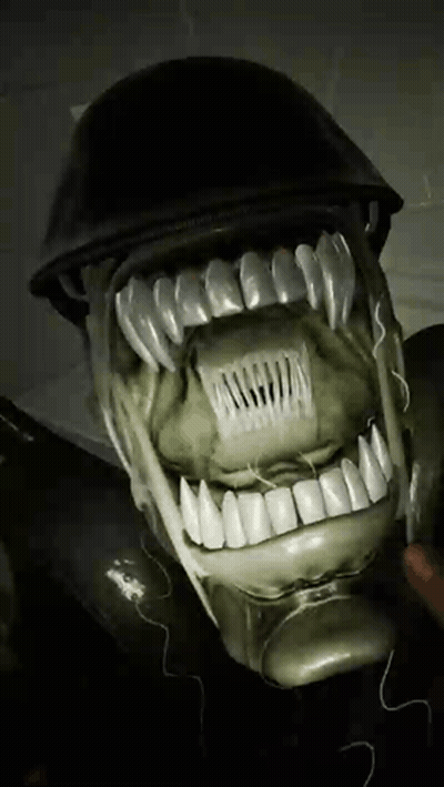 A Close Up Of A Person 'S Face With Teeth And A Helmet On It GIF