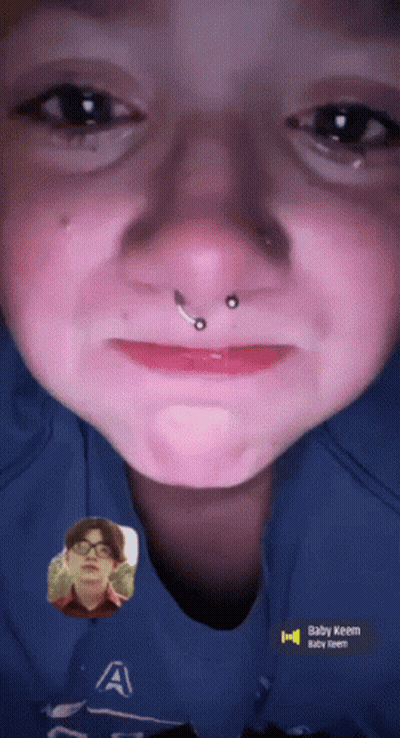 A Close Up Of A Person 'S Face With The Name Baby Keem On The Bottom GIF