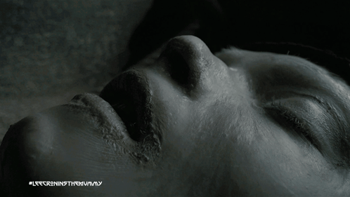 A Close Up Of A Person 'S Face With The Words " Lee Cronin 'S The Mummy " On The Bottom Right GIF