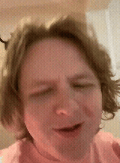 A Close Up Of A Person 'S Face With Their Eyes Closed And Their Hair Blowing In The Wind . GIF
