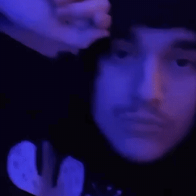 A Close Up Of A Person 'S Face With Their Eyes Closed And Their Hand On Their Forehead . GIF