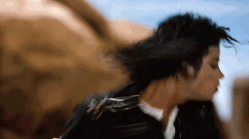 A Close Up Of A Person 'S Face With Their Hair Blowing In The Wind GIF