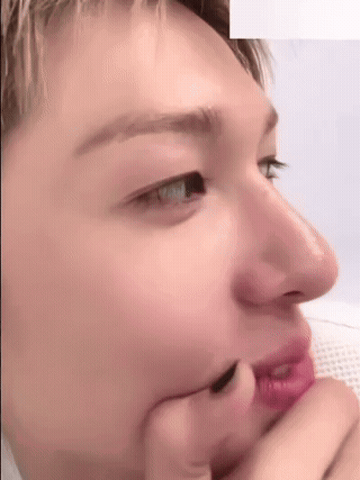 A Close Up Of A Person 'S Face With Their Hand On Their Face . GIF